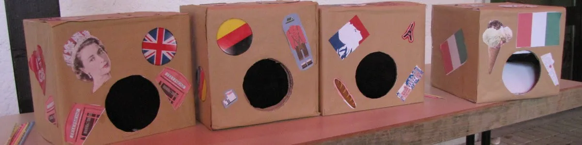 Vier Fühlboxen aus Karton, beklebt mit Flaggen und Bildern aus Großbritannien, Deutschland, Frankreich und Italien